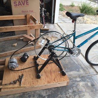 a bicycle is parked next to a box and some other items on the ground outside.jpg