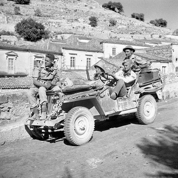 13 July 1943 - members of Cdn Public Relations #1 unit move through Modica, Sicily, in their j...jpg
