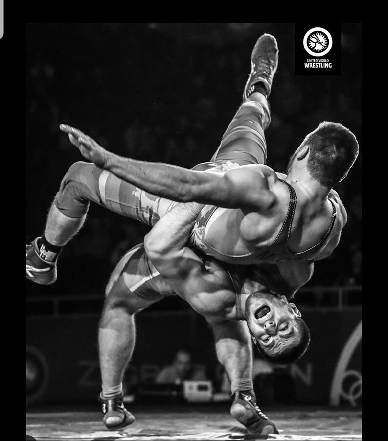 a man is doing a handstand on another man's back in a wrestling ring.jpg