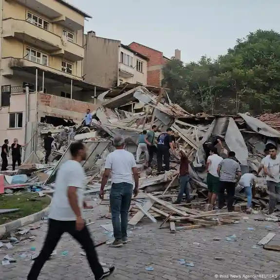 Deprem sonrası çöken bir binanın etrafında insanlar